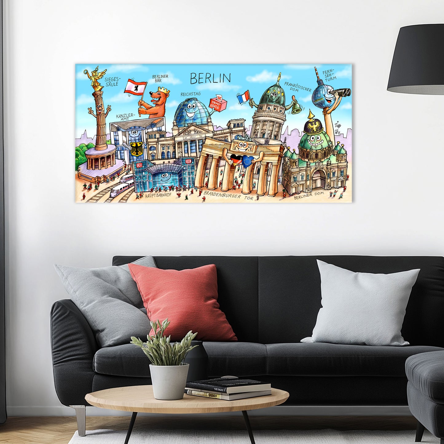 Jacques Tilly Berlin Stadtbild auf Leinwand mit Holzrahmen über einem schwarzen Sofa mit einem roten und zwei grauen Kissen und einem runden Couchtisch aus Holz davor.