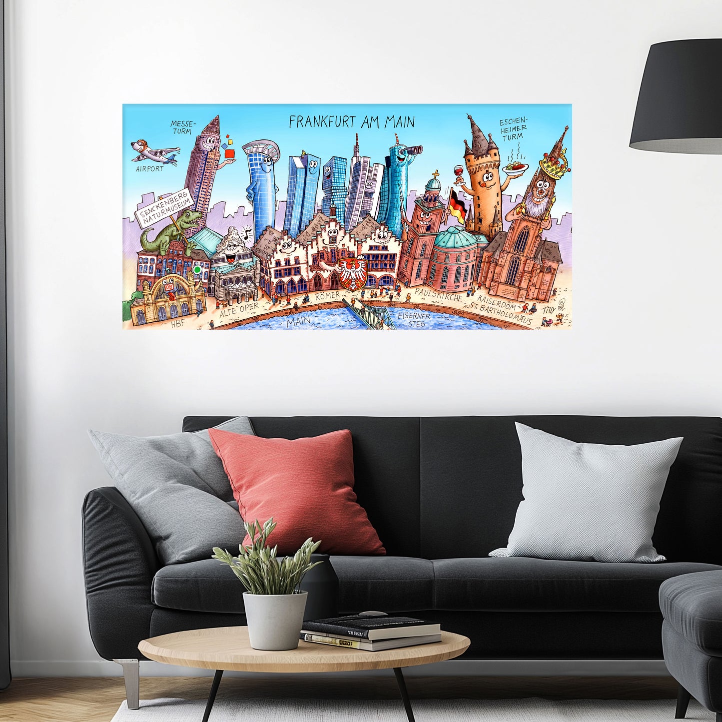 Jacques Tilly Frankfurt am Main Stadtbild auf Leinwand mit Holzrahmen über einem schwarzen Sofa mit einem roten und zwei grauen Kissen und einem runden Couchtisch aus Holz davor.