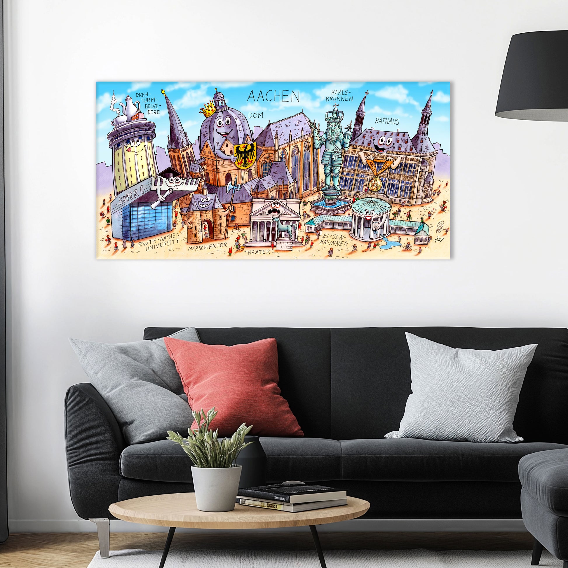 Jacques Tilly Aachen Stadtbild als Acrylbild mit Alu-Rückrahmen über einem schwarzen Sofa mit einem roten und zwei grauen Kissen und einem runden Couchtisch aus Holz davor.