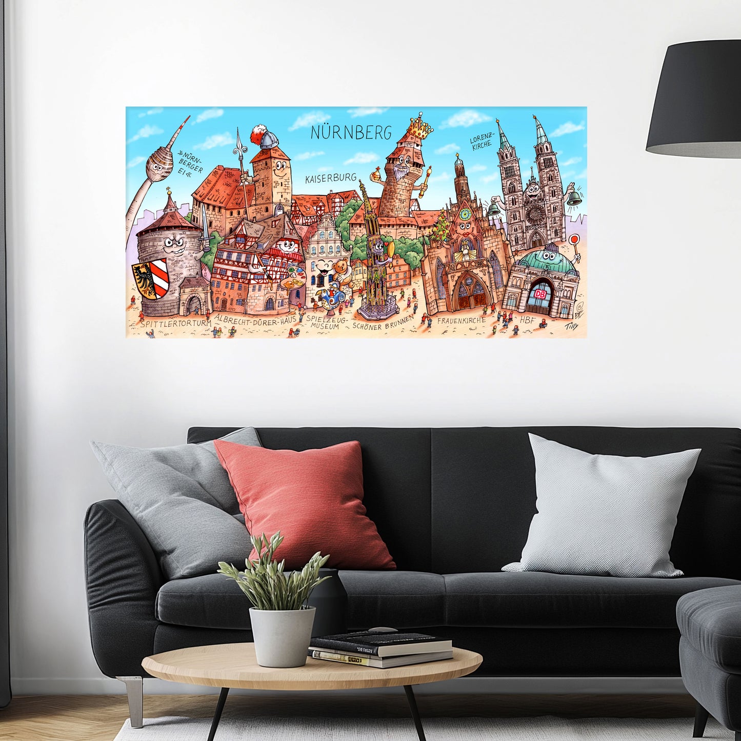 Jacques Tilly Nürnberg Stadtbild auf Leinwand mit Holzrahmen über einem schwarzen Sofa mit einem roten und zwei grauen Kissen und einem runden Couchtisch aus Holz davor.